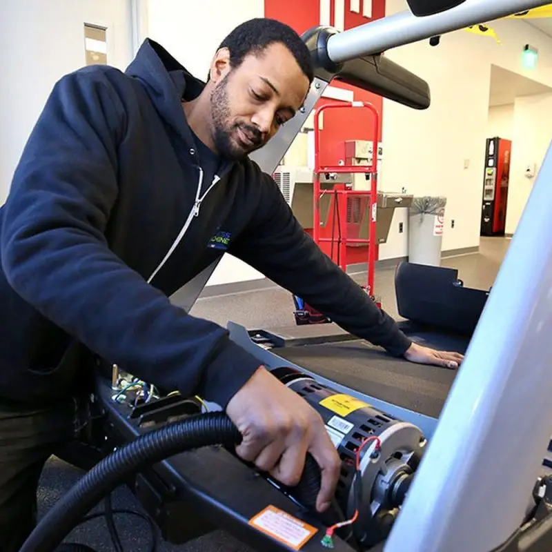 Certified technician repairing treadmill motor and belt – Gym equipment service in UAE